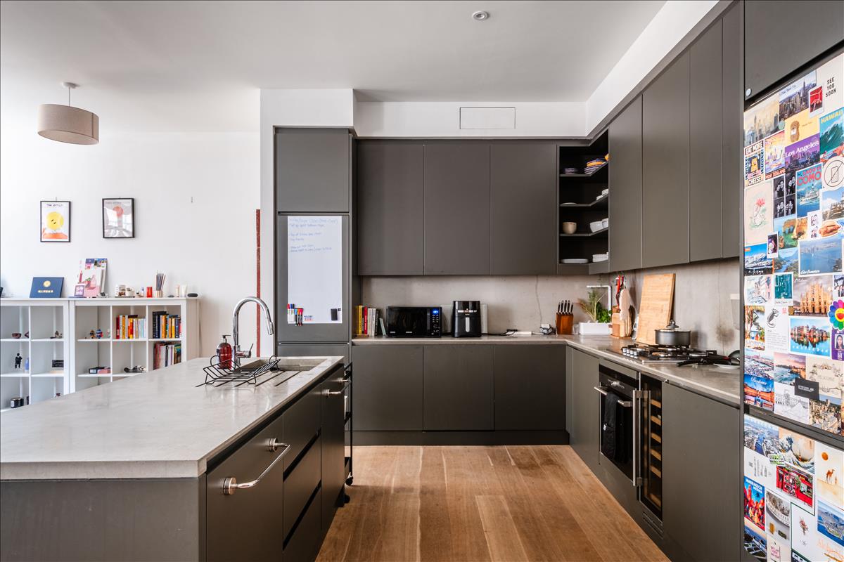 Kitchen - Set within a beautifully reimagined Victorian warehouse in the heart of Clerkenwell, this exceptional two-bedroom apartment combines industrial heritage with contemporary refinement. Occupying part of a thoughtfully converted late-19th-century building, the apartment extends to an impressive 1,368 sq ft, with soaring ceilings exceeding three metres, expansive factory-style glazing and carefully considered interiors throughout.