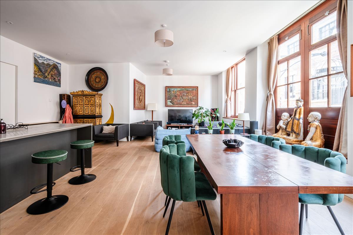 Living Room - Set within a beautifully reimagined Victorian warehouse in the heart of Clerkenwell, this exceptional two-bedroom apartment combines industrial heritage with contemporary refinement. Occupying part of a thoughtfully converted late-19th-century building, the apartment extends to an impressive 1,368 sq ft, with soaring ceilings exceeding three metres, expansive factory-style glazing and carefully considered interiors throughout.