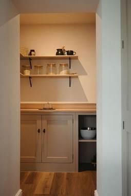 A kitchen with shelves and utensils
AI-generated content may be incorrect.